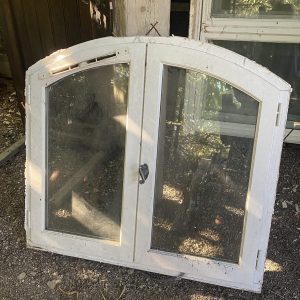 Fenêtre demi cintre avec son encadrement en bois peint blanc. 2 vantaux ouverture centrale.